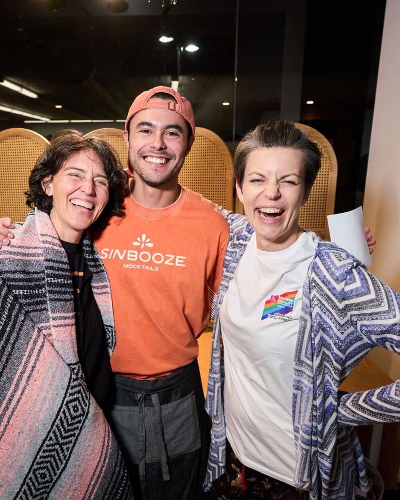 Sin Booze founder Aldo Covarrubias smiles between two guests at an event