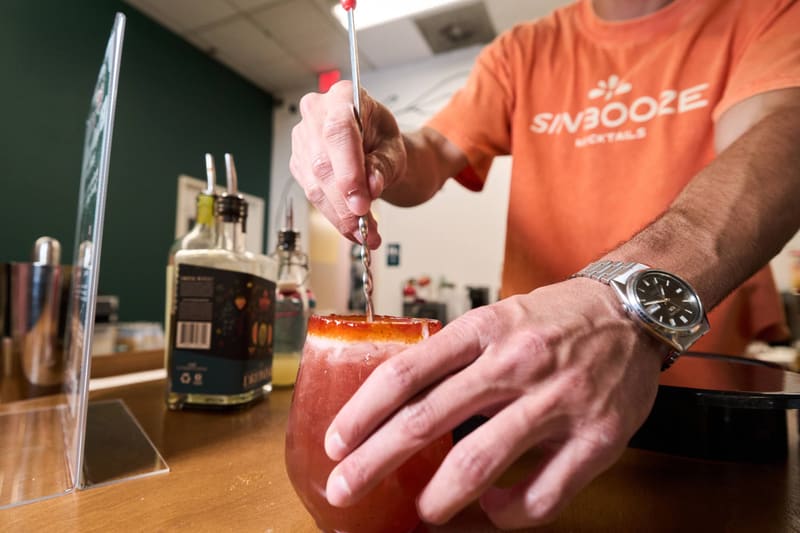 Aldo stirs a rimmed mocktail at the Sin Booze bar