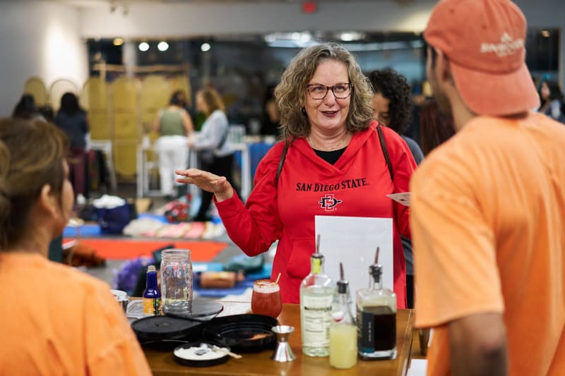 A guest laughs while ordering at the Sin Booze bar