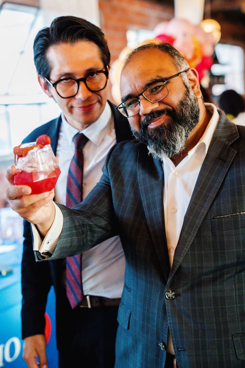 Guests in suits toast with Sin Booze mocktails