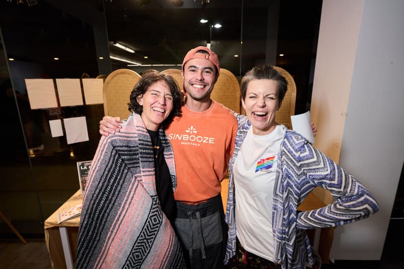 Aldo hugs two smiling guests at an event