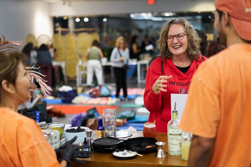 A guest laughs with the Sin Booze team across the bar